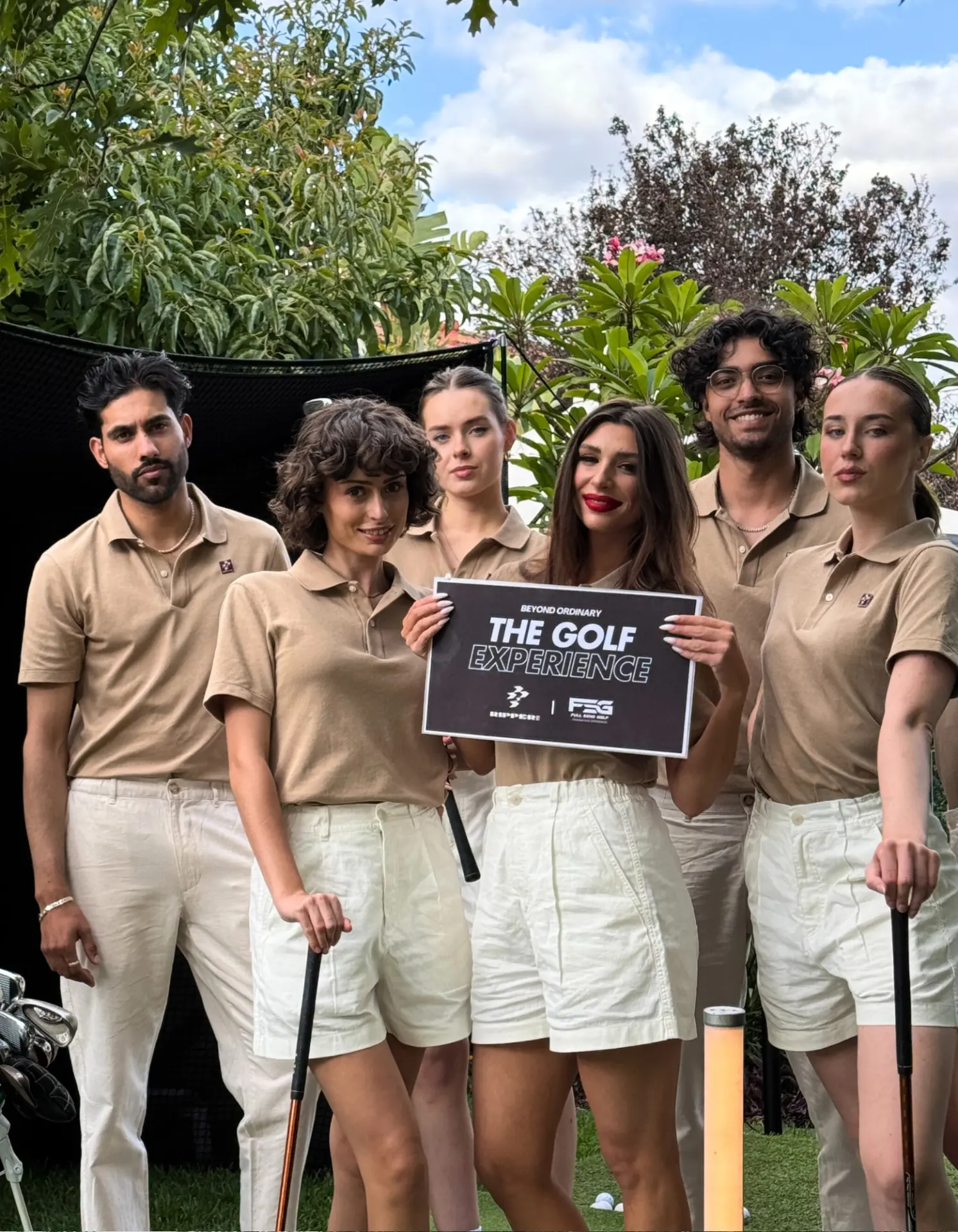 The Golf Experience brand team holding the event sign at a Ripper garden activation in Adelaide