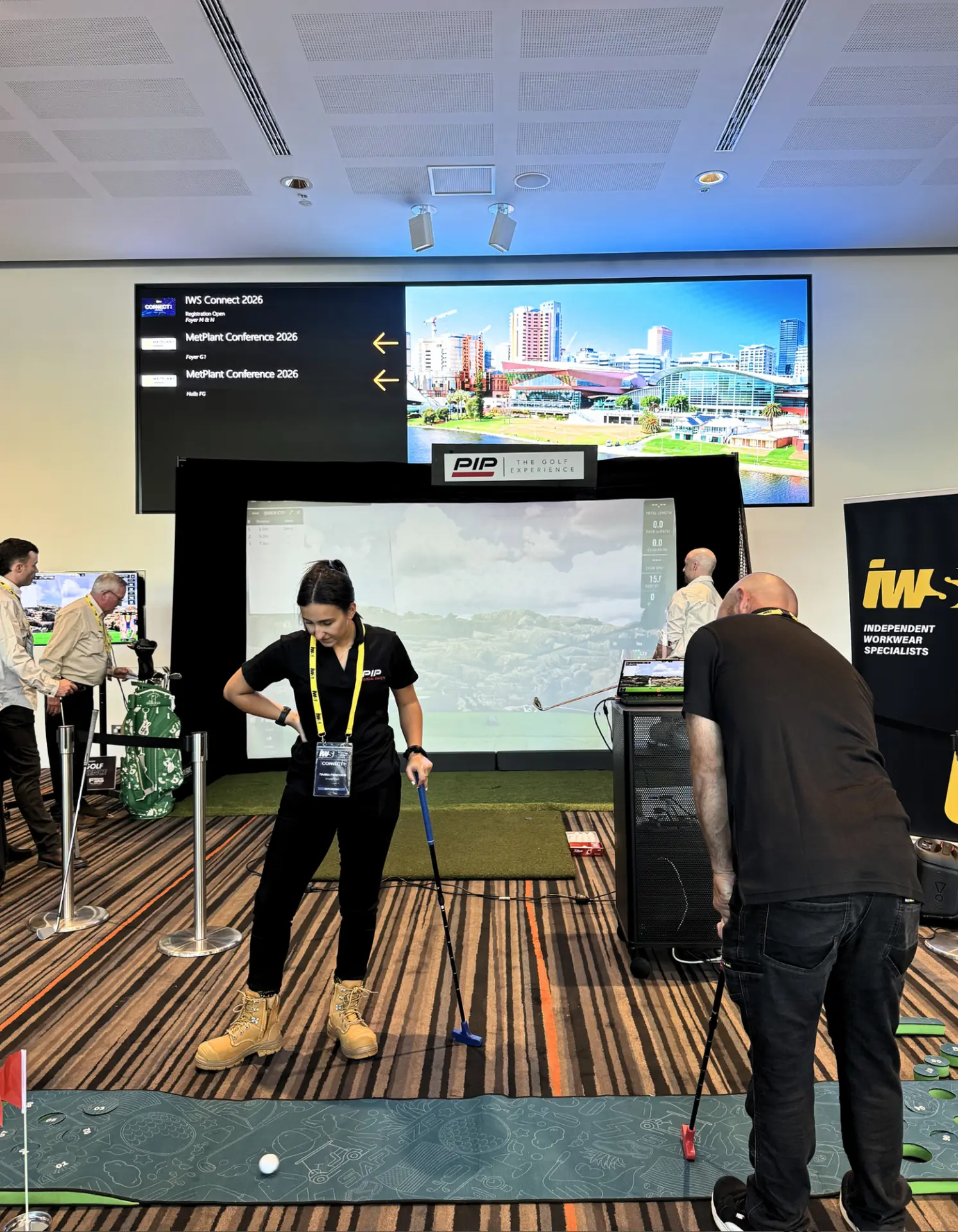 Conference guests putting on a golf simulator green at a corporate event in Adelaide
