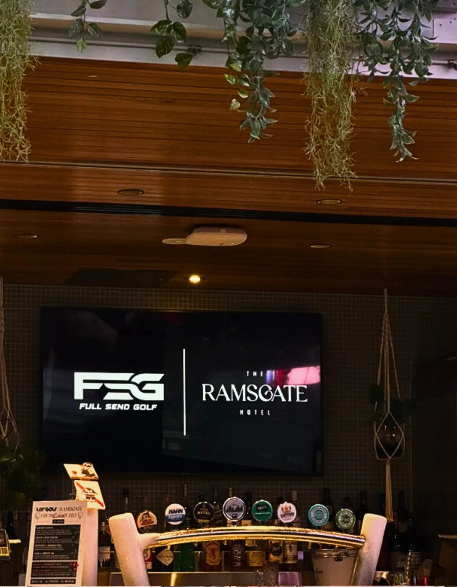 Full Send Golf and The Ramsgate Hotel branding on the big screen above the bar at a golf simulator hire event in Adelaide