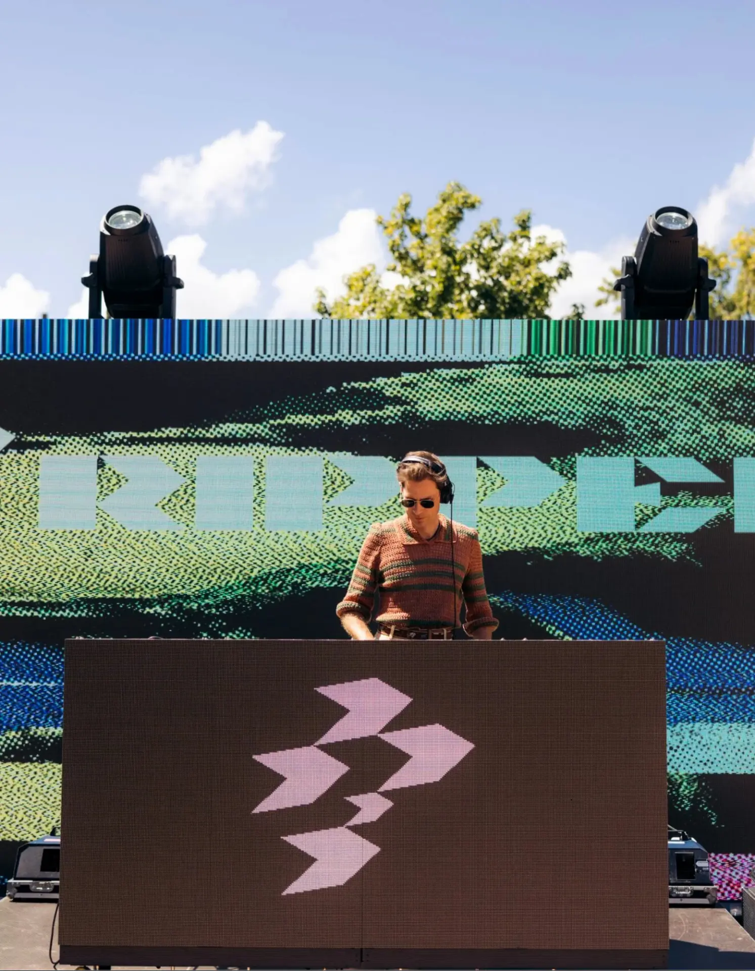 DJ performing on an outdoor stage at a Full Send Golf event in Adelaide with LED screens and festival production