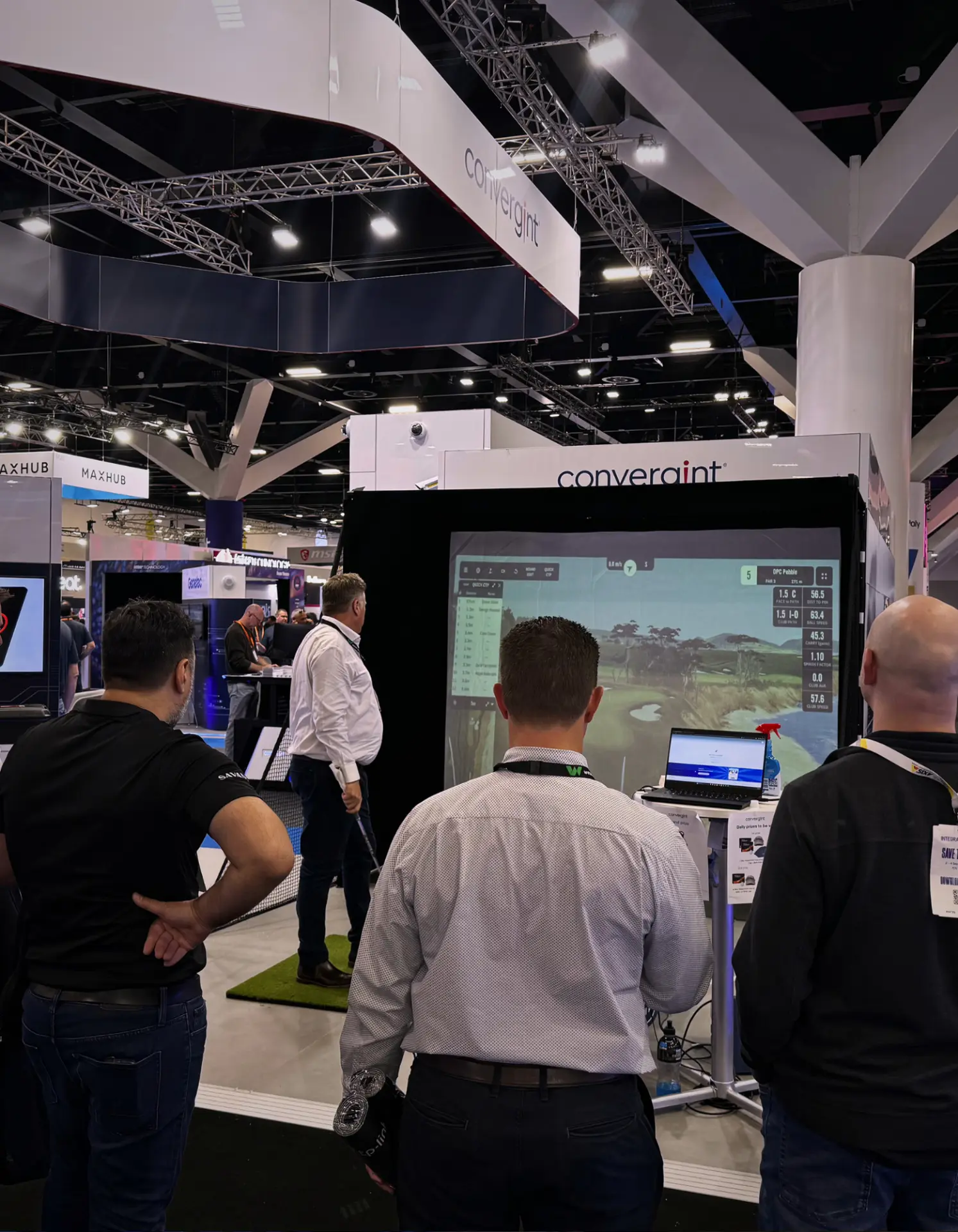 Expo crowd watching a golf simulator round at the Convergint stand during an Adelaide trade show