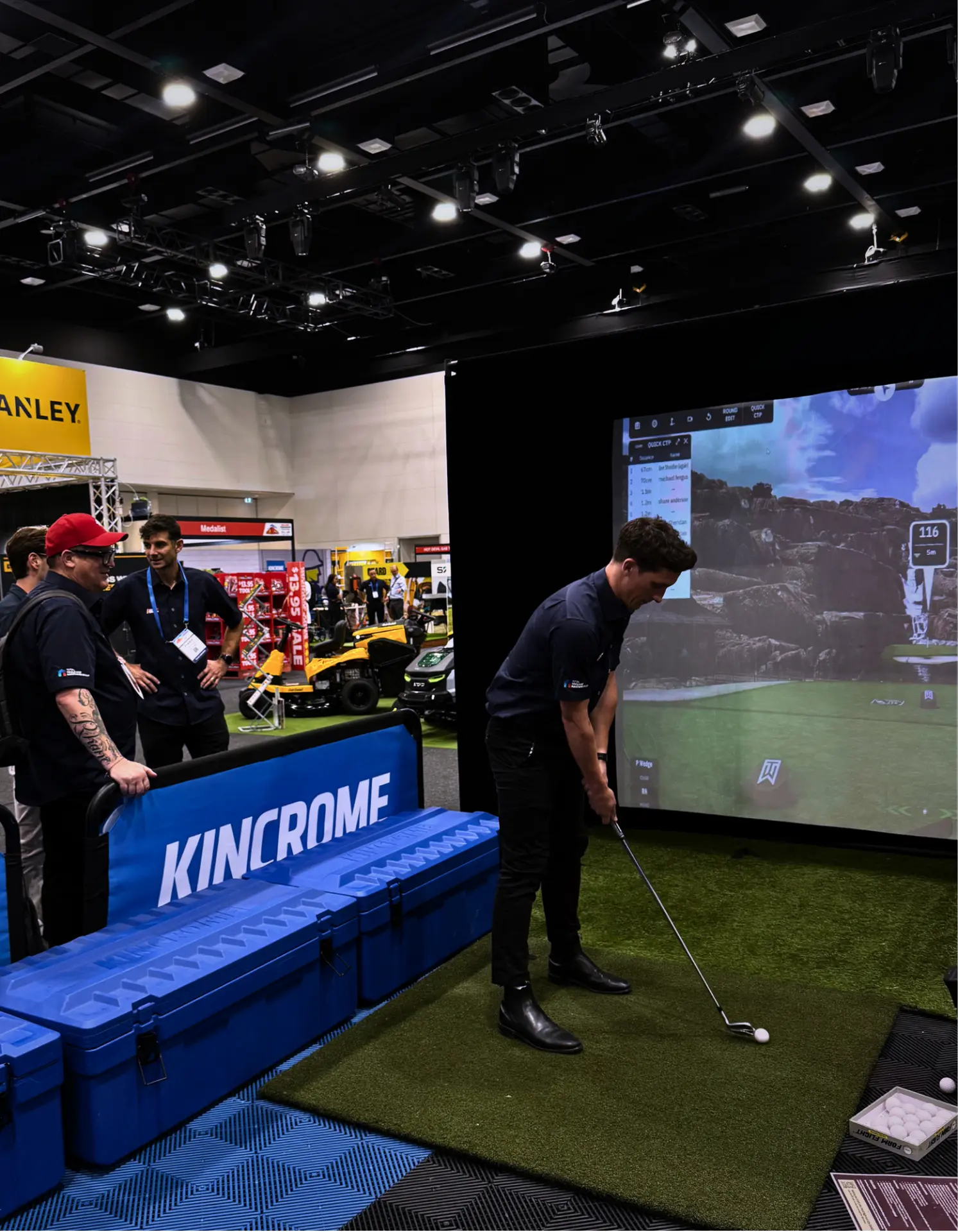 Guest hitting a shot on a trade show golf simulator hire setup at the Kincrome stand in Adelaide