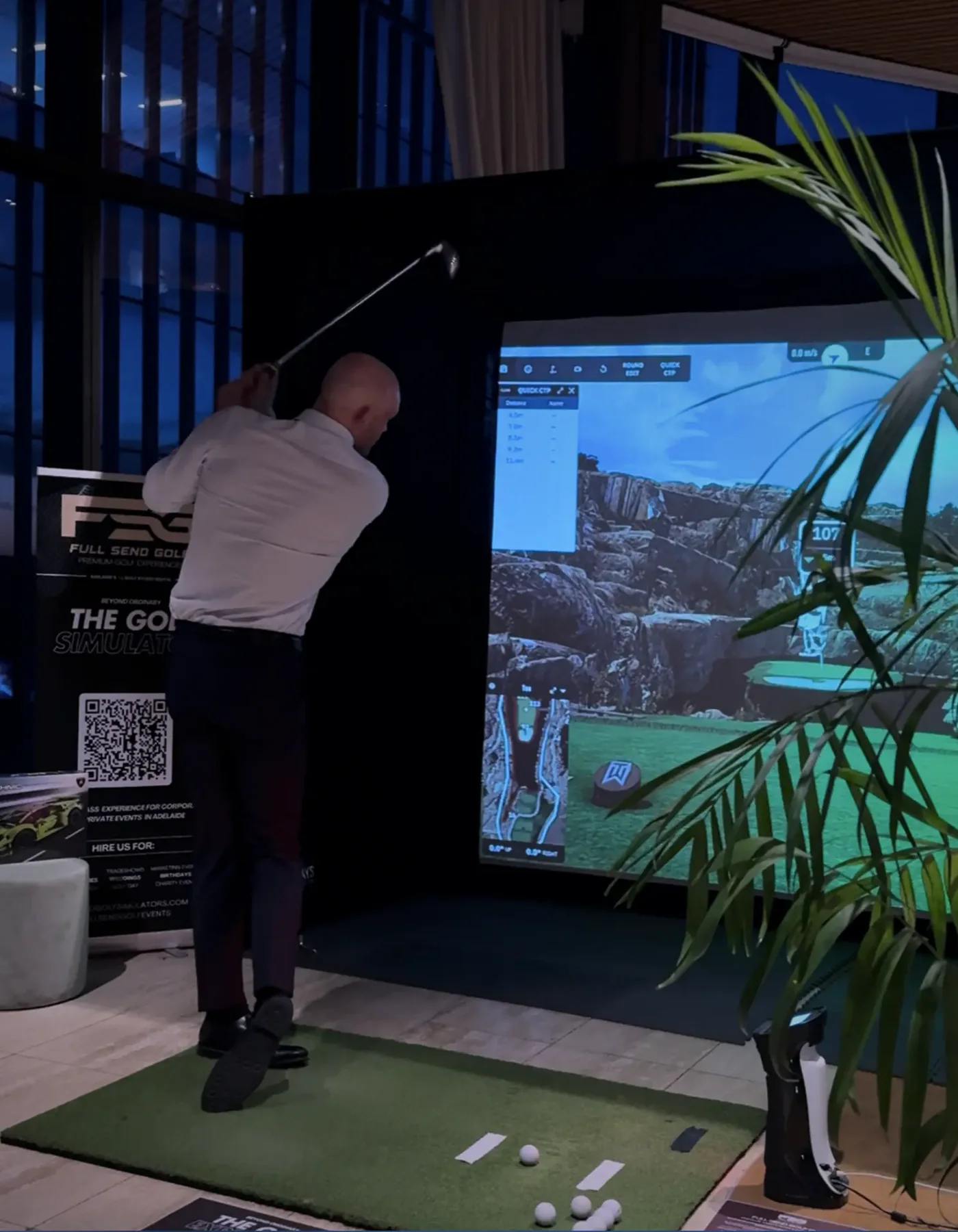 Corporate guest taking a shot on The Tee Box golf simulator at an Adelaide function