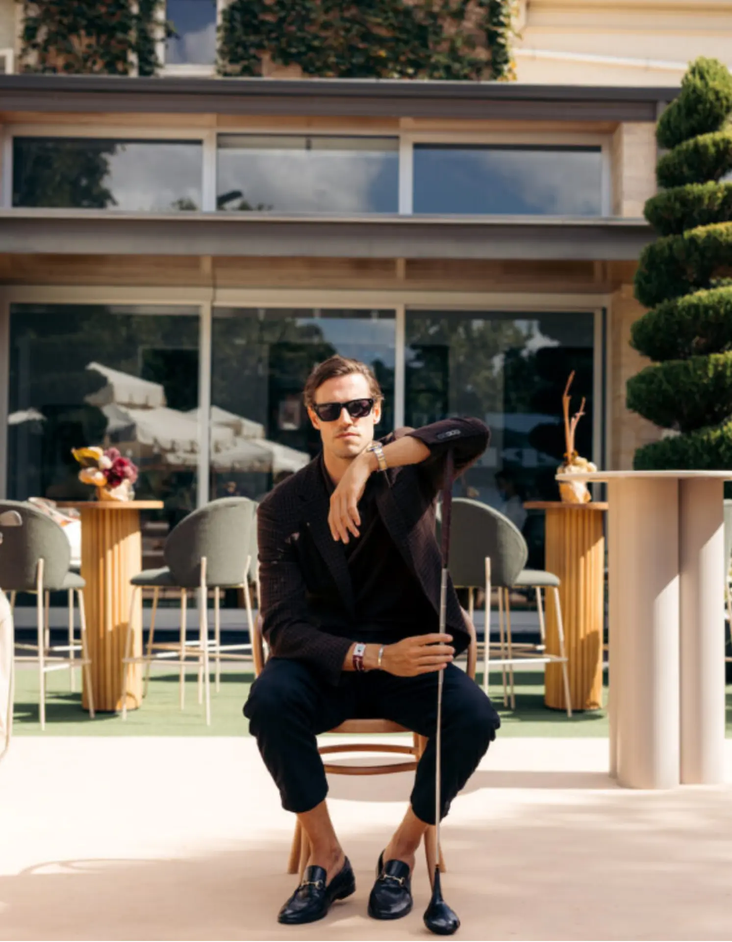 Guest posing with a golf club at a premium private venue golf event in Adelaide with styled outdoor furniture